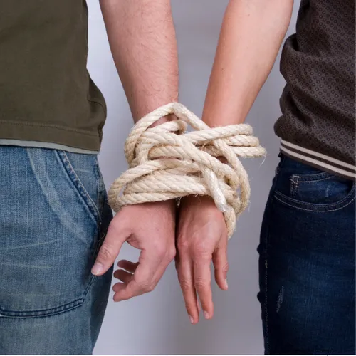 Couple aux poignets liés par une corde, symbolisant la dépendance affective et le manque d'autonomie émotionnelle