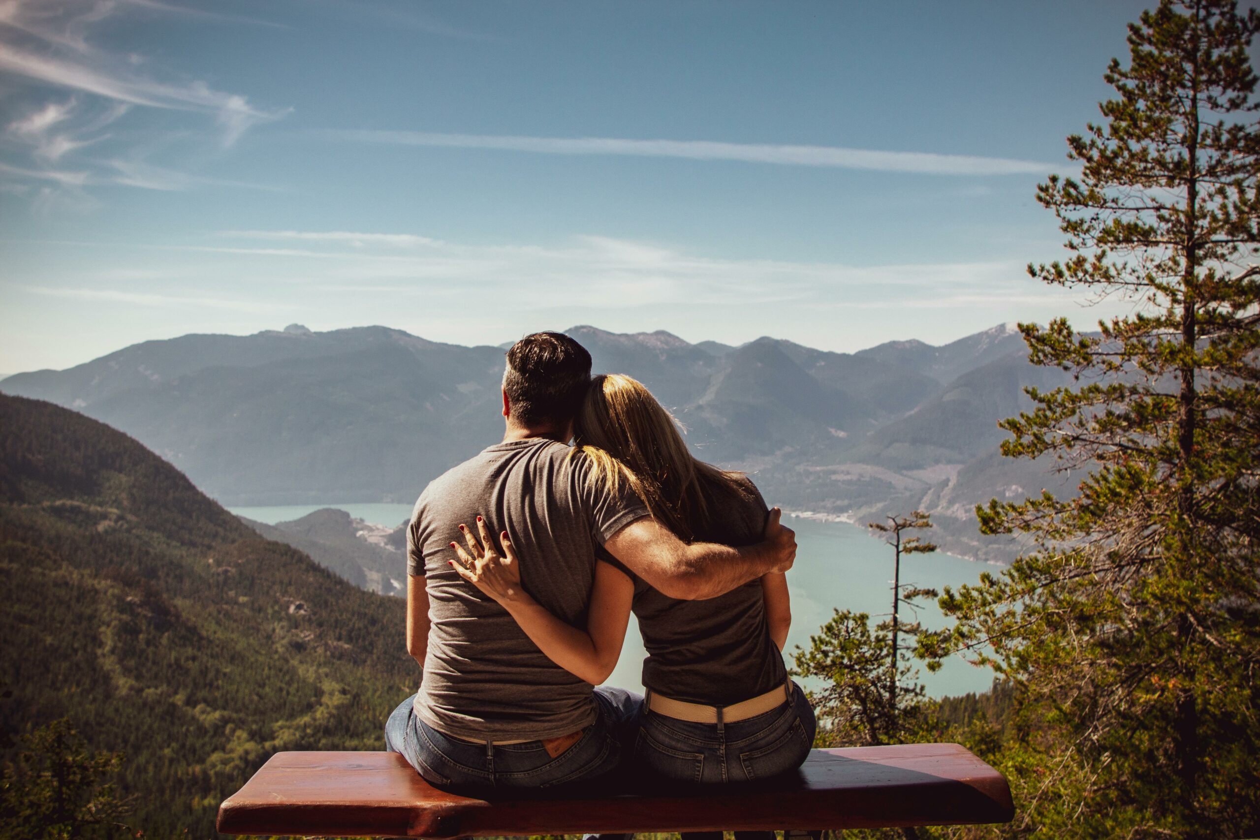 Couple assis ensemble face à un paysage de montagne, représentant la connexion émotionnelle et les enjeux de la dépendance affective